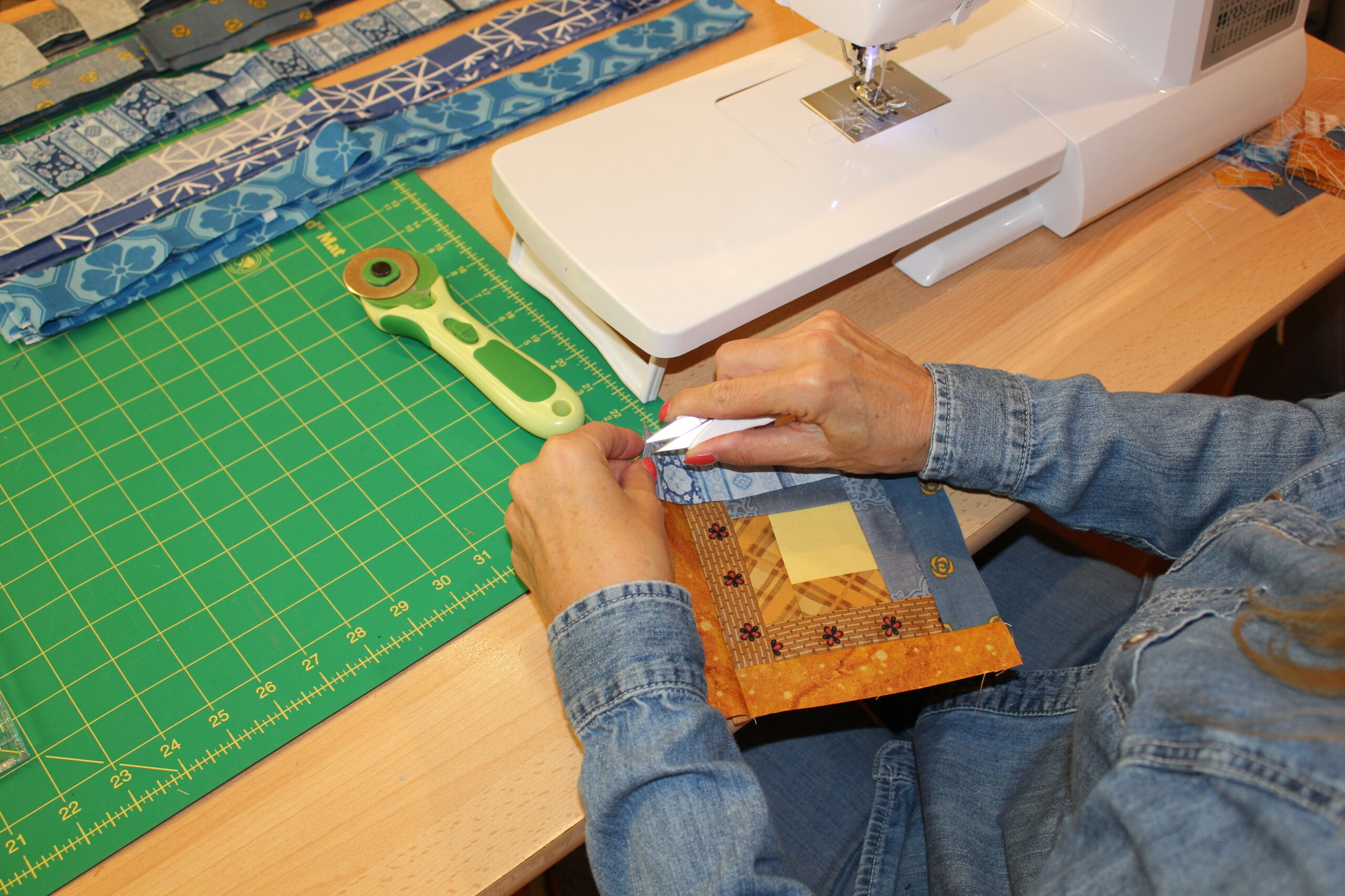 Tracy pinning patchwork block at sewing machine for matching quilt points