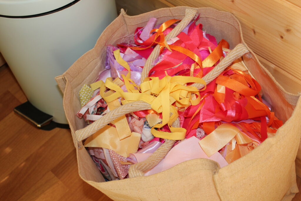 linen bag overflowing with colourful fabric scraps for crumb quilting