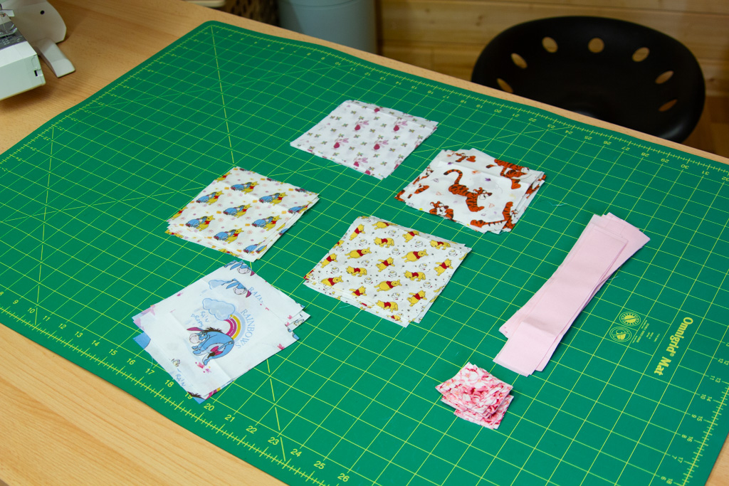 six fabric squares laid out on a cutting mat ready for a beginner quilt block project