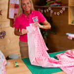 Tracy holding quilting fabric and smiling in her sewing studio — scared to start quilting